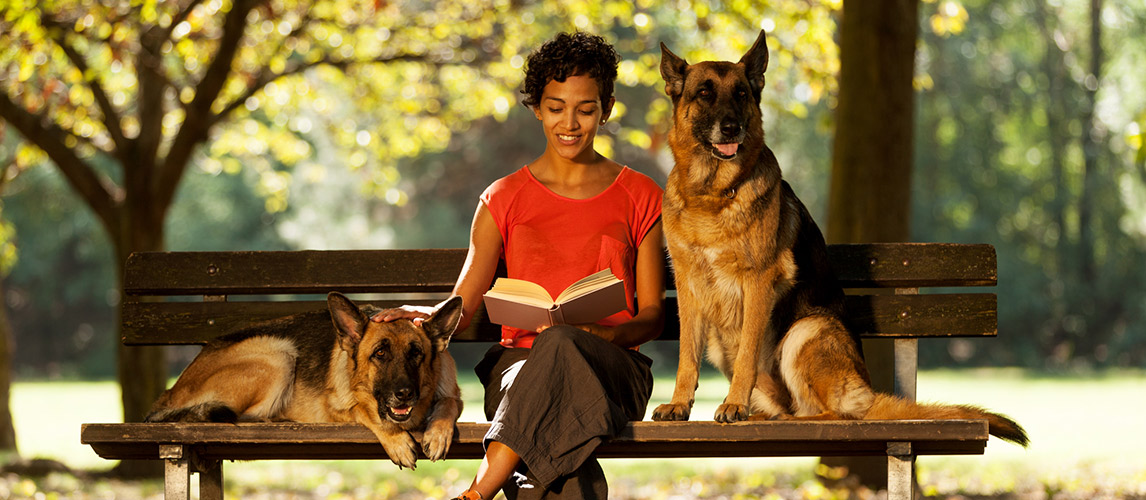 Woman-is-sitting-with-two-german-shepherds